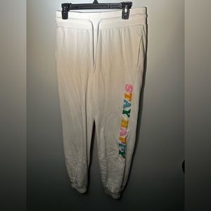 White graphic “Stay Happy” sweat pants. Size medium, Revolution